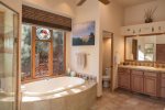 The master bathroom is spacious with a large tub and walk-in shower